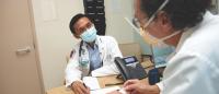 medical student in white coat speaks with senior physician